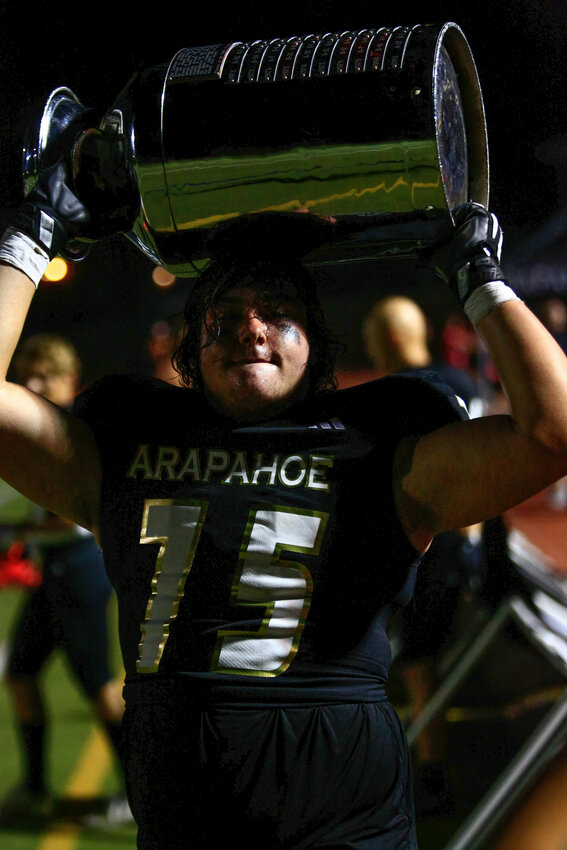Arapahoe's Danny Ballas holds onto the Milk Jug after his team's victory. Arapahoe now has bragging rights for another year.